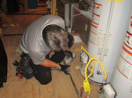 George Gibbons, owner of G2 Home Inspections, inspecting a water heater
